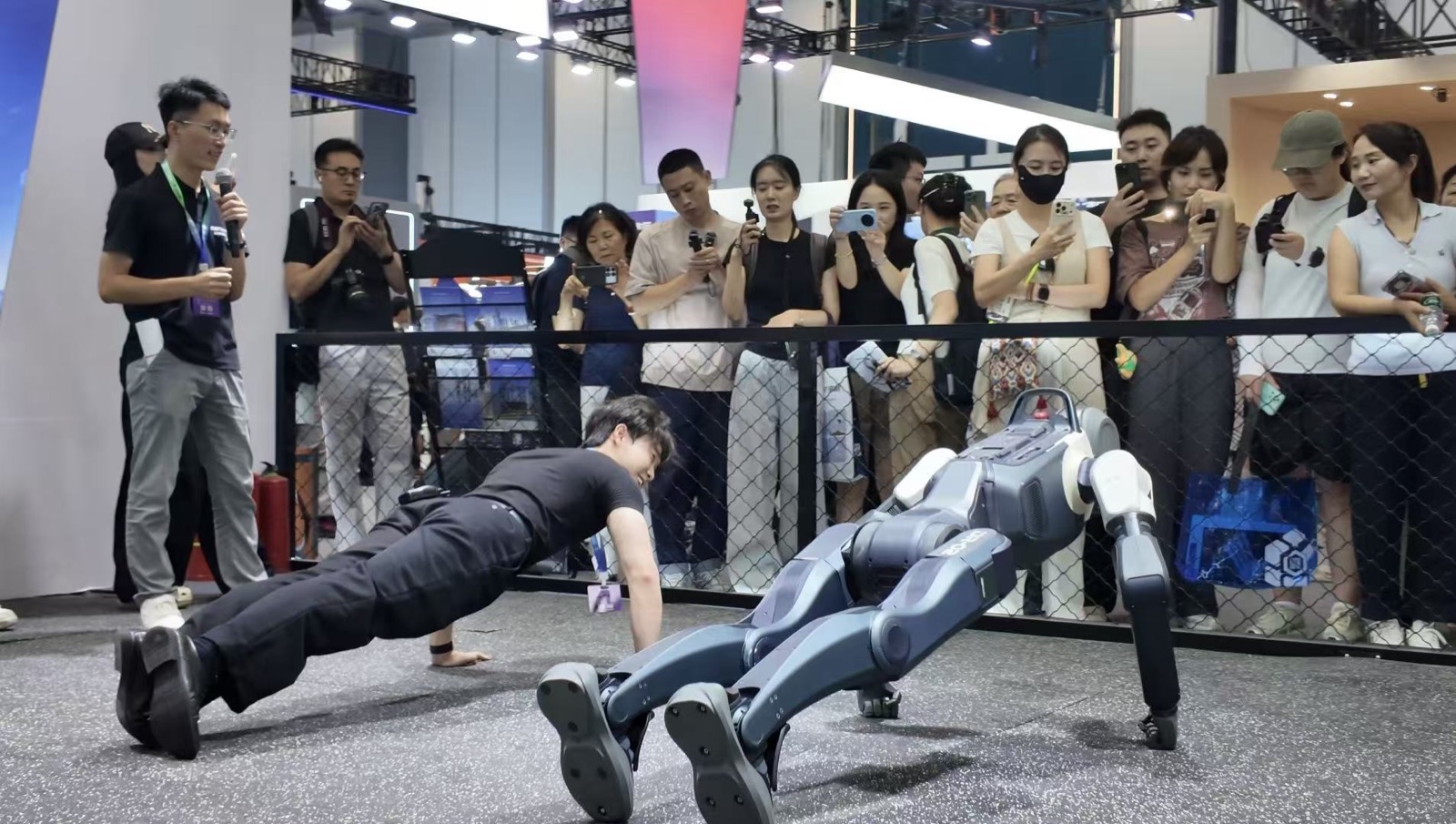 DEEP Robotics DR02 humanoid robot doing push-ups next to a human at World Robot Conference 2026 in Beijing